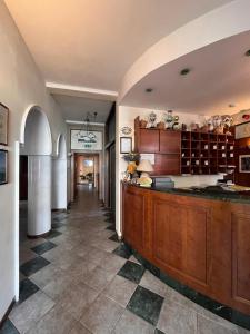 eine große Küche mit Holzschränken und Fliesenboden in der Unterkunft HOTEL LUDOVICO ARIOSTO in Castelnuovo di Garfagnana