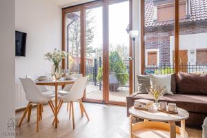 a living room with a table and a couch at Flatbook Apartamenty - Mikoszewo Dom Amber Cottage in Nickelswalde