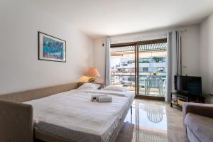 two beds in a room with a television and a couch at Résidence Gray d'Albion Studio BRA507 in Cannes