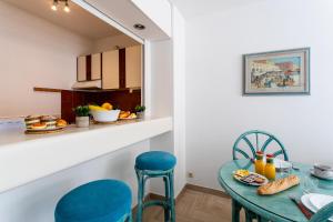 a dining room with a table and chairs and a kitchen at Résidence Gray d'Albion Studio BRA507 in Cannes