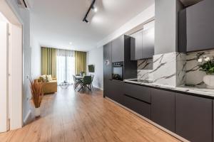 uma cozinha com armários pretos e uma sala de estar em Modern Central Apartment em Durrës