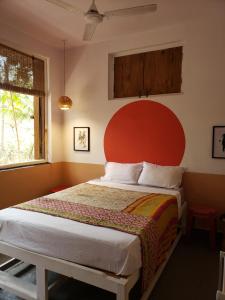 a bedroom with a large bed with a red headboard at Adi Shakti Guesthouse in Querim