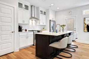a kitchen with a black island and white cabinets at The Oakley - Near Lake Fayetteville in Fayetteville