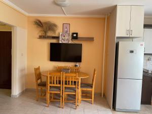 a dining room with a table and a refrigerator at Calm island near the Danube - free parking in Budapest