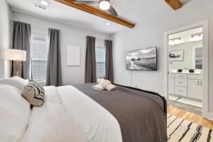 ein Schlafzimmer mit einem großen weißen Bett und einem Spiegel in der Unterkunft The Oakley - Near Lake Fayetteville in Fayetteville