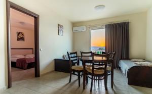 Zimmer mit Tisch und Stühlen in einem Hotelzimmer in der Unterkunft Golden Rose Suites in Kolimvárion