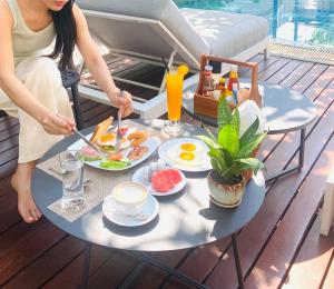 a woman is eating breakfast on a table at Athena Hotel in Pakse