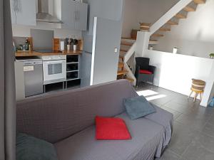 格呂桑的住宿－Jolie Maison au centre du village，客厅配有带红色枕头的灰色沙发
