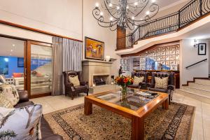 a living room with a table and a fireplace at Hyde Park Guest House in Johannesburg