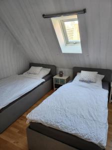 2 camas individuales en una habitación con ventana en Ferienwohnung Langhammer, en Schonungen