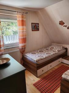 Cama pequeña en habitación con ventana en Ferienwohnung Langhammer, en Schonungen