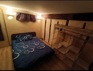 een kleine kamer met een bed en een plank bij Maison sur 3 étages, proche de Disneyland in Jouarre
