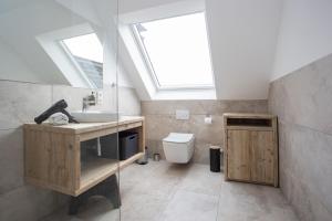 La salle de bains est pourvue d'un lavabo et de toilettes avec une lucarne. dans l'établissement Appartement - Winterbergerstrasse 3 - Winterberg-Neuastenberg, à Winterberg