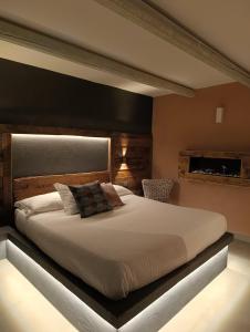 a bedroom with a large bed with a black headboard at Trulli Terra Magica in Putignano