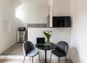 a dining room with a table with a laptop and two chairs at Easylife - Suite in Porta Venezia in Milan