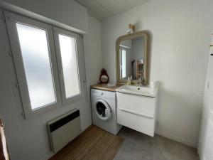a bathroom with a washing machine and a sink at Grand Studio centre ville, gare et plage à pied in Pornichet +12 photos