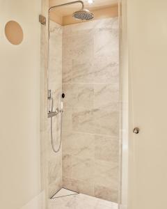 y baño con ducha y puerta de cristal. en Villa Dahlia en Estocolmo