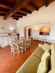 a living room with a couch and a table with chairs at Villa Claudia piscina privata in Stintino +24 photos