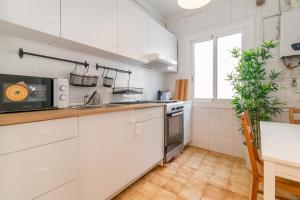 uma cozinha branca com um lavatório e um fogão em RONDA em Barcelona