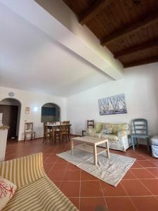 a living room with a couch and a table at Villa Olivastro Piscina privata in Stintino