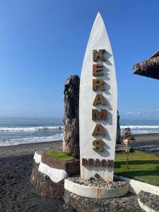 a sign on the beach with the ocean in the background at Villa Casablanca Surf Keramas in Keramas