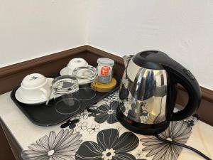 a tea kettle sitting on top of a table at The Lodge in Kuala Kerai
