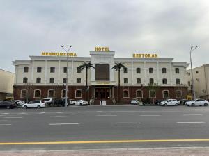 a large building with cars parked in a parking lot at Zilol Baxt Hotel in Samarkand