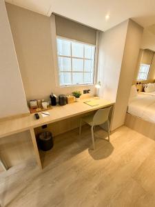 a room with a desk with a bed and a window at Urbanwood Hung Hom in Hong Kong