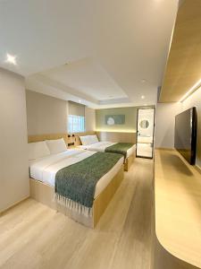 a hotel room with two beds and a flat screen tv at Urbanwood Hung Hom in Hong Kong
