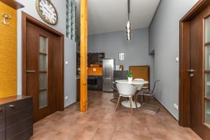 a kitchen with a table and a clock on the wall at Oktogon 4 Entire Aircon Apartment in Budapest