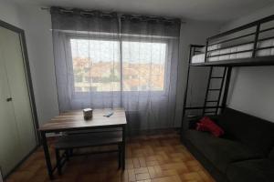 Schlafzimmer mit einem Schreibtisch und einem Etagenbett in der Unterkunft Charming accommodation on the Port of Gruissan in Gruissan