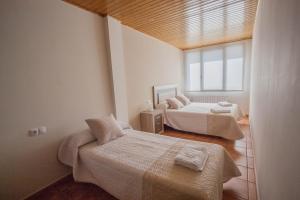 una camera con due letti e una finestra di Apartamentos Mirador a Gúdar