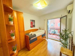 1 dormitorio con 1 cama y balcón en El Lago del Pilar ComoTuCasa, en Zaragoza
