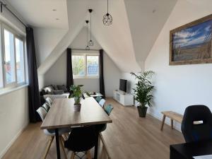 a living room with a table and a couch at Duinroos vlakbij strand in Egmond aan Zee