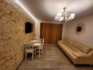 a living room with a couch and a table at R&R Apartament in Ocna-Mureşului