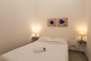 ein weißes Bett in einem Zimmer mit zwei Lampen in der Unterkunft Freres PradignacLAT1101 in Cannes