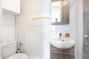 a white bathroom with a sink and a toilet at GuestReady - Cosy studio in Saint-Maur-des-Fossés in Joinville-le-Pont +3 photos