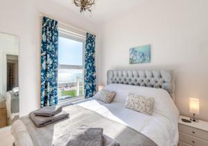 a bedroom with a large bed with a window at Coastal Nest - Hythe in Hythe