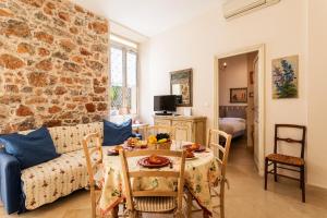 een woonkamer met een tafel en een bakstenen muur bij Frères Pradignac in Cannes