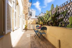 een patio met 2 stoelen en een tafel op een balkon bij Frères Pradignac in Cannes