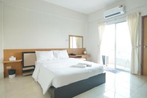 sypialnia z dużym łóżkiem i dużym oknem w obiekcie โกอินน์ สนามบินสุวรรณภูมิ GO INN Suvarnabhumi Airport w Lat Krabang