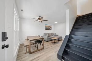 ein Wohnzimmer mit einem Deckenventilator und einem Tisch in der Unterkunft Shore Break at CB - 1 Block to Beach Access in Carolina Beach