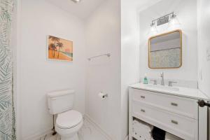 ein weißes Badezimmer mit Toilette und Waschbecken in der Unterkunft Shore Break at CB - 1 Block to Beach Access in Carolina Beach + 11 Fotos