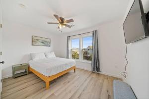 ein Schlafzimmer mit einem Bett und einem Fenster in der Unterkunft Shore Break at CB - 1 Block to Beach Access in Carolina Beach