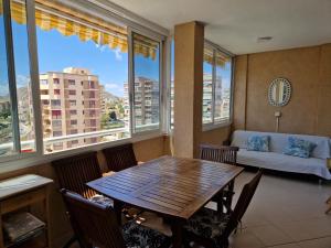 アリカンテにあるPiso para vacaciones en Alicanteのリビングルーム(テーブル、ソファ、窓付)