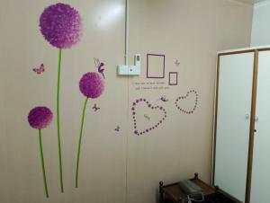a room with purple flowers on the wall with a mirror at seaview hostel in George Town