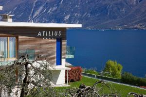 a building with a sign that reads atilums next to the water at Hotel Atilius in Limone sul Garda