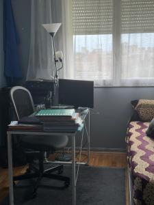 Cette chambre comprend un bureau avec un ordinateur et une chaise. dans l'établissement Joli appartement avec vue sur la Tour Eiffel, à Villejuif