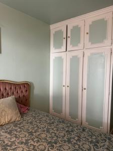 - une chambre avec un lit et des armoires blanches dans l'établissement Joli appartement avec vue sur la Tour Eiffel, à Villejuif 3 autres photos