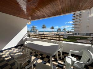 a table and chairs on a balcony with a view of the beach at Dúplex Altamar Solo Familias Serviplaya in Gandía
